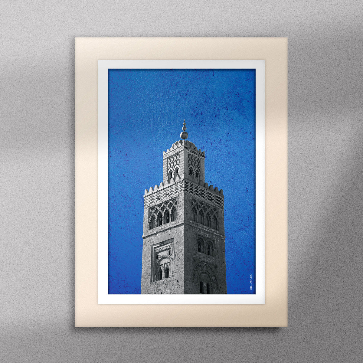 Tableau décoratif représentant la Koutoubia de Marrakech sur un fond bleu, encadré dans un cadre en bois - Format A5.