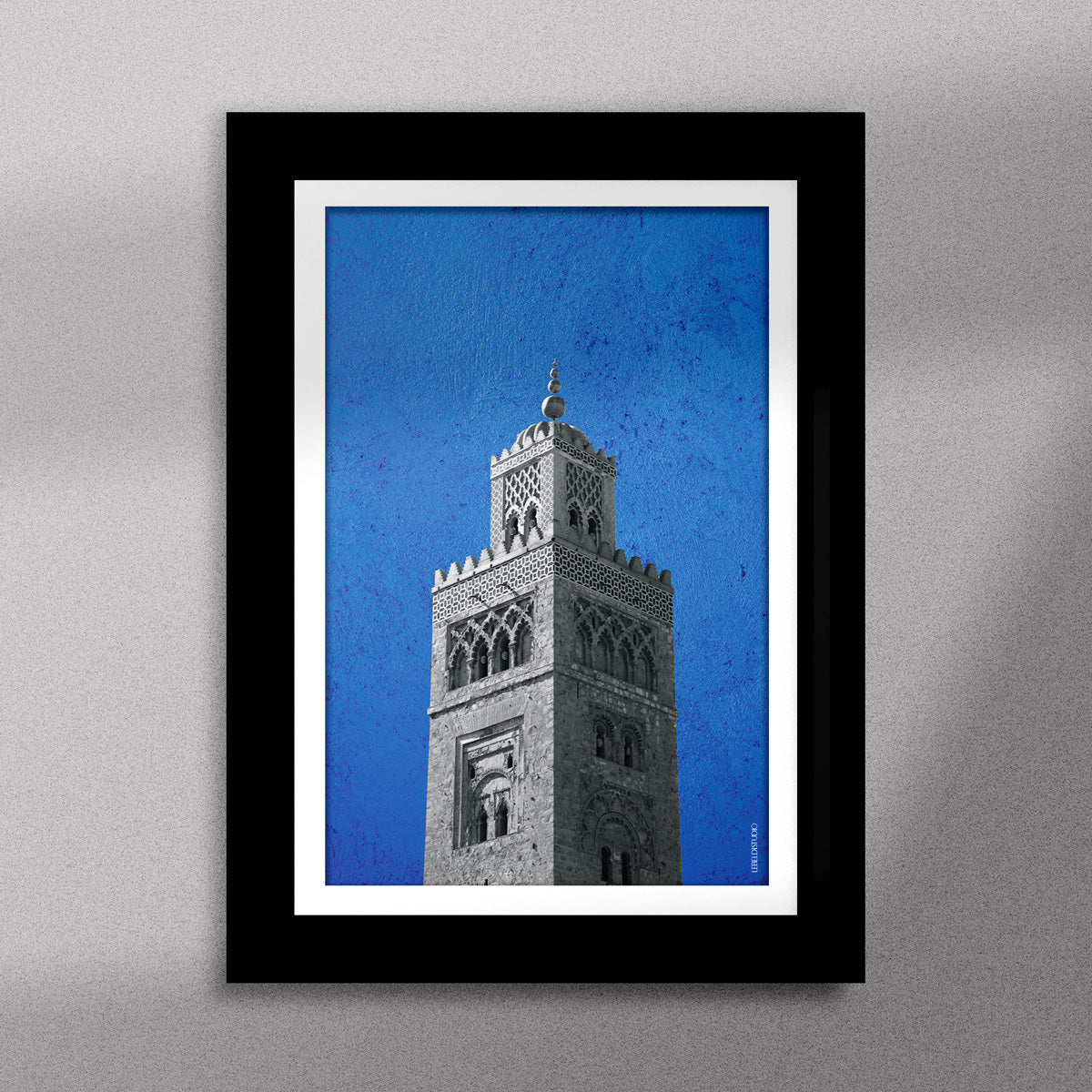 Tableau décoratif représentant la Koutoubia de Marrakech sur un fond bleu, encadré dans un cadre noir - Format A5.