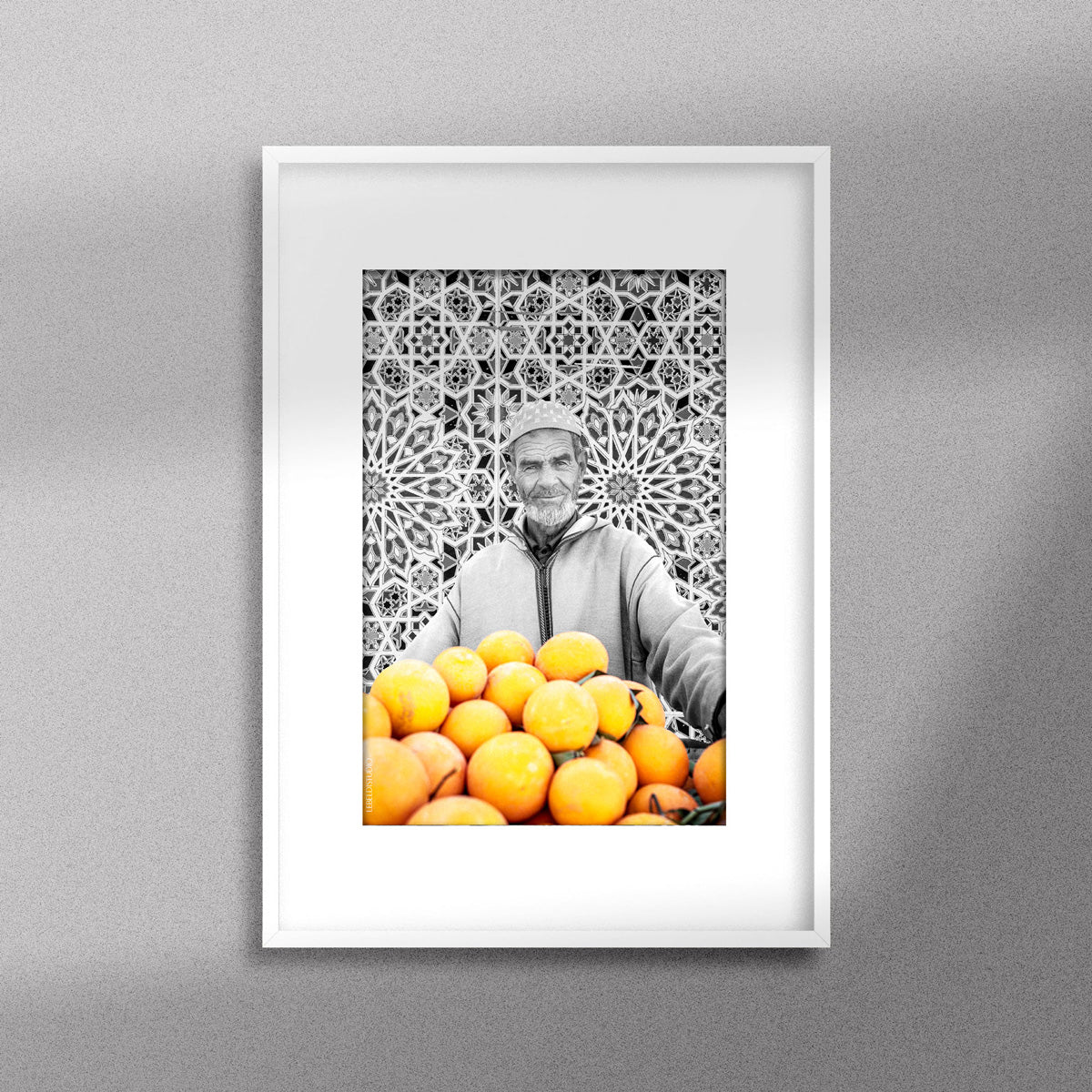 Tableau décoratif en noir et blanc d'un vieux marchand d'oranges très souriant, encadré dans un cadre blanc - Format A3.