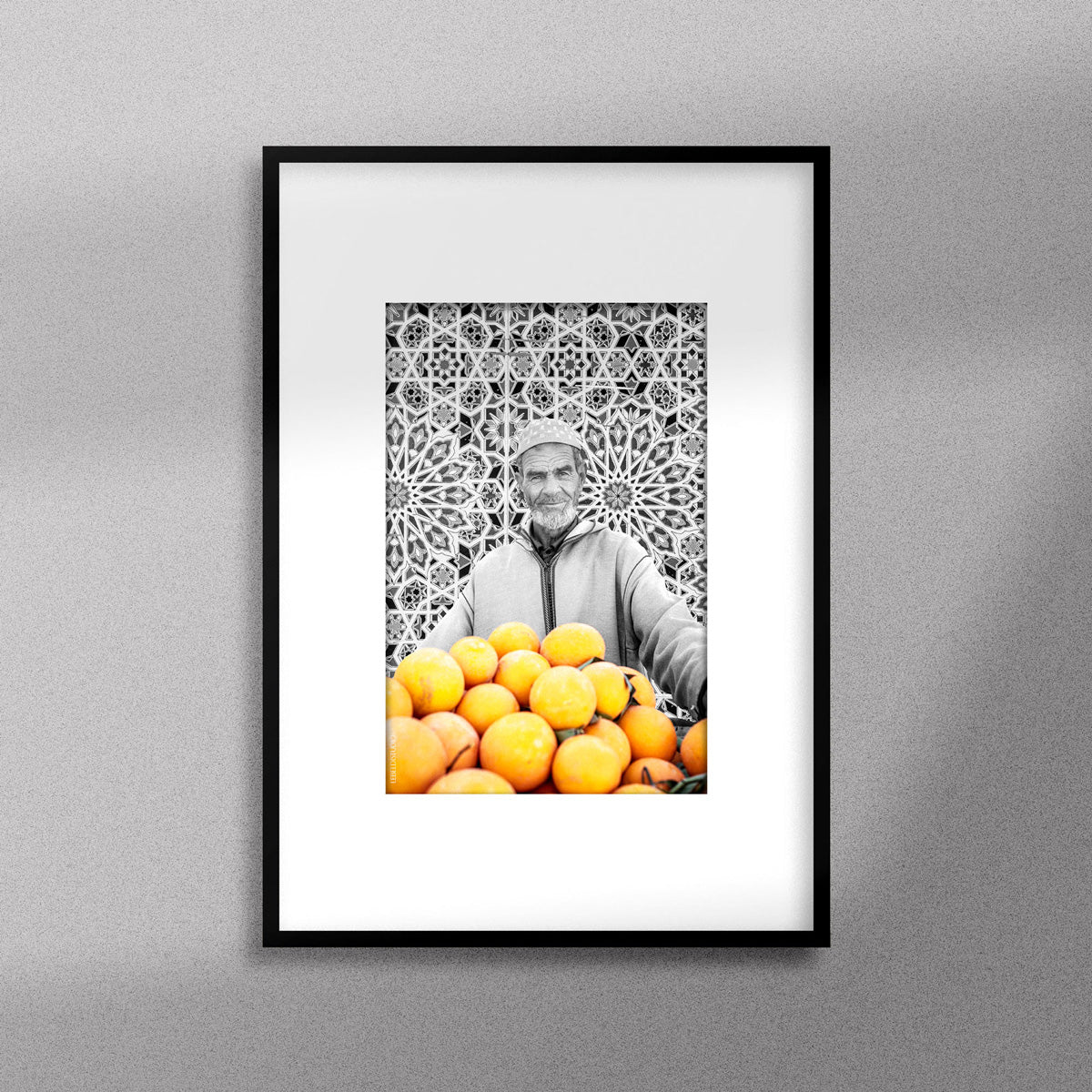Tableau décoratif en noir et blanc d'un vieux marchand d'oranges très souriant, encadré dans un cadre noir - Format A4.